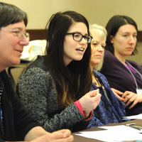 An early career researcher makes her point while other scientists look on