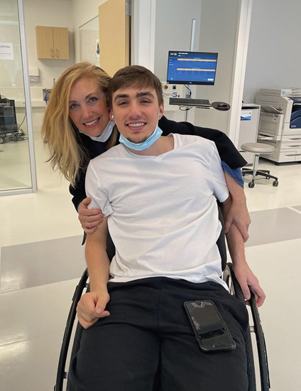 Feature-art_Dr-Perez_8 A mother and her teenage son smile for the camera. The son is sitting in a wheelchair.